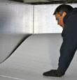 contractor installing TerraBlock™ floor insulation in a Middlesboro crawl space