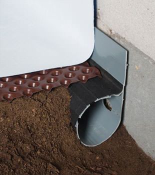 Closeup of a crawl space drainage system installed in Columbia
