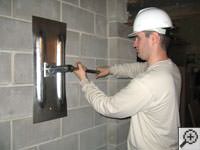 Attempting to straighten a bowed foundation wall by straightening a wall anchor system in a Middlesboro home.
