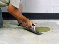 Repairing the cored holes in the concrete slab floor with fresh concrete and cleaning up the Middlesboro home.