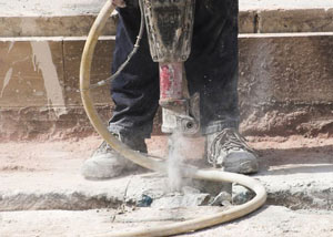 Jackhammering a slab floor in a Berea home.