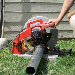Cutting the support beam for a crawl space jack post outside a Middlesboro home.