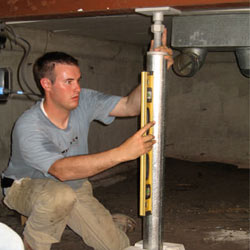 A contractor in Campbellsville installing a crawl space jack post.