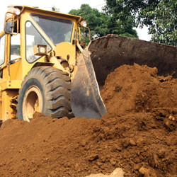 Construction equipment excavating soils during a foundation construction