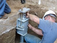 Foundation repair contractors installing the foundation bracket in Georgetown.