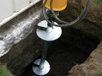 Installing a helical pier system in the earth around a foundation in Nicholasville