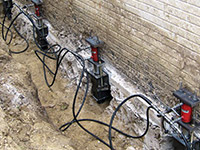 Using foundation push piers to lift a foundation during a repair in Somerset.