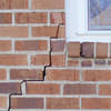 long jagged cracks starting at the corner of a window along a brick wall on a Corbin home