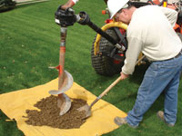 Auguring a hole in the earth for a foundation wall repair system in Middlesboro