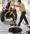 Digging a hole in the garage floor to make room for a wall anchor installation in East Bernstadt, Kentucky