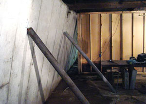 A severely tilting foundation wall propped up by steel beams in Stearns.