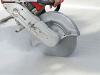 Cutting the driveway for expansion joints during street creep repair in Mc Kee