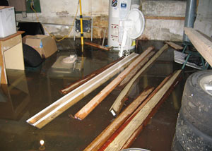 A severely flooding basement in Middlesboro, with lumber and personal items floating in a foot of water
