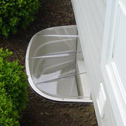 A vinyl basement window and covered window well in Williamsburg