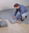 Contractors installing basement subfloor tiles and matting on a concrete basement floor in Danville, Kentucky
