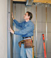 Insulated basement wall panels being placed against a concrete foundation wall in Berea